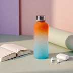 Gradient water bottle with measurement markings on a light surface.