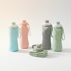 Set of colorful collapsible water bottles on a wooden table with a home interior background.